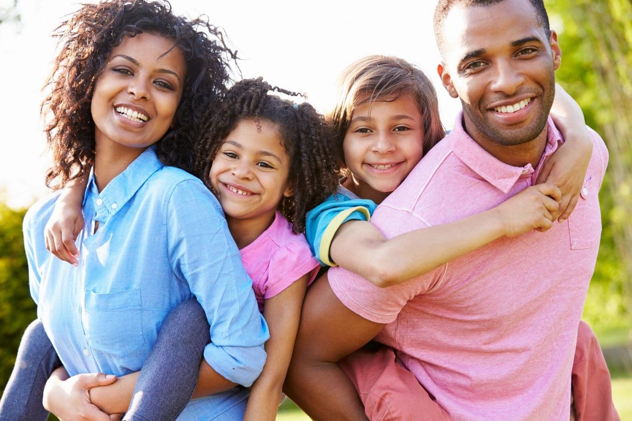 A family smiling together outdoors